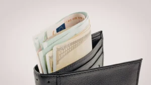 Portefeuille en cuir noir contenant des billets en euros pour illustrer le budget logement et les aides APL de la CAF