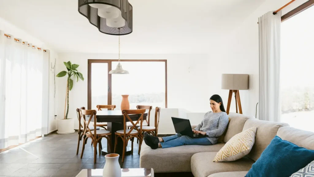 Locataire réalisant un état des lieux de sortie dans un salon lumineux, inspection du logement avant restitution et comparaison avec l’entrée en 2026.