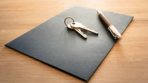 Clés et stylo posés sur un dossier de location, illustration du statut bailleur privé et des démarches immobilières en 2026.